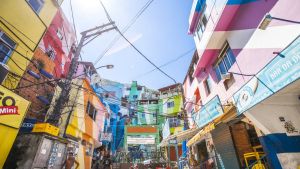 Everyday life in Santa Marta favela, town square named Praca Cantao surrounded by colourful buildings.