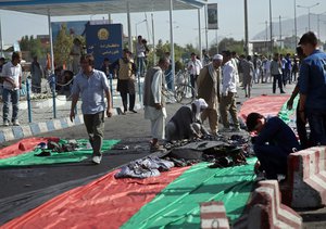 Afghan men gather the suicide attack victim's properties after a suicide attack happened during a demonstration in Kabul, Afghanistan, Saturday, July 23, 2016.  Afghan Health Ministry officials say at least 31 people have been killed and 160 wounded in the bombing of a protest march in the capital, Kabul. (AP Photos/Massoud Hossaini)