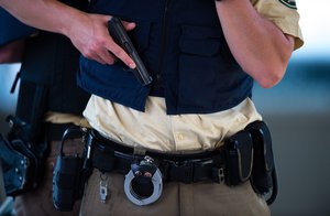 Police officer holds a gun near the Olympia shopping centre after a shooting was reported there in Munich, southern Germany, Friday, July 22, 2016.