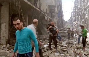 File: In this image made from video and posted online from Validated UGC, a man carries a child after airstrikes hit Aleppo, Syria, Thursday, April 28, 2016.