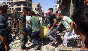 In this photo released by the Syrian official news agency SANA, Syrians carry a victim after twin bombings struck Kurdish town of Qamishli, Syria, Wednesday, July 27, 2016. Twin bombings struck a crowd in a predominantly Kurdish town in northern Syria on Wednesday, killing 44 people and wounding dozens more, Syria’s state-run news agency and Kurdish media reported. (SANA via AP)