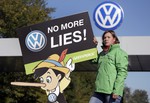 An activist of the environmental protection organization 'Greenpeace' holds a protest poster in front of a factory gate of the German car manufacturer Volkswagen in Wolfsburg, Germany, Friday, Sept. 25, 2015, where the supervisory board meet to discuss who to name as CEO after Martin Winterkorn quit the job this week over an emissions-rigging scandal that's rocking the world's top-selling automaker.