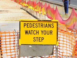 A pedestrian walks close to oncoming traffic as he heads along the north Stuart Highway near Head st. The delay in repair of the footpath has forced walkers closer to the road