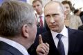 Russian President Vladimir Putin talks with International Olympic Committee President Thomas Bach.