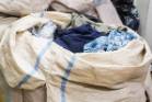 Clothing piled high in sacks from charity bins is dealt with on the sorting floor of the St Vinnies Newtown store.