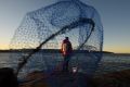 Doyun Kim, 31, from Strathfield, fishing in chilly conditions on the rocks near Fairlight Beach in Sydney. 