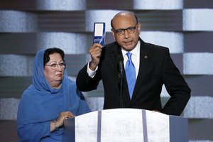 Khizr Khan, father of fallen US Army Capt. Humayun S. M. Khan holds up a copy of the Constitution of the United States as his wife listens