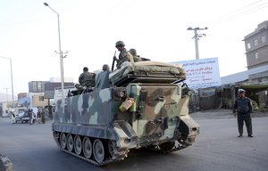 Afghan National Army sit on their tank passing a road leading to the site of an explosion, in Kabul, Afghanistan, Monday, Aug. 1, 2016.