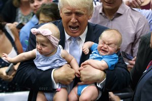 Republican presidential candidate Donald Trump holds Kellen Campbell of Denver, right, and Evelyn Keane, of Castle Rock, Colo., during a campaign rally, Friday, July 29, 2016, in Colorado Springs, Colo.