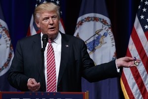 Republican presidential candidate Donald Trump holds a Purple Heart medal given to him by a supporter during a campaign rally at Briar Woods High School, Tuesday, Aug. 2, 2016, in Ashburn, Va.