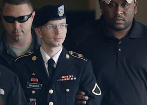 In this Tuesday, Aug. 20, 2013, file photo, Army Pfc. Bradley Manning is escorted to a security vehicle outside a courthouse in Fort Meade, Md., after a hearing in his court martial.