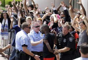 File - Activist DeRay McKesson is arrested by St. Louis and Federal Protective Service police outside the Thomas F. Eagleton Federal Courthouse, Monday, Aug. 10, 2015, in St. Louis. Several protesters were arrested.