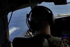 File - U.S. Navy Lt. j.g. Brent Nelsen scans the water while flying a P-8A Poseidon aircraft over the Indian Ocean, April 4, 2014, during a search mission for Malaysia Airlines Flight 370.