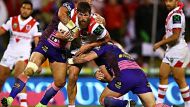 Dragon Will Matthews gets tackled by Broncos players at WIN Stadium on August 4, 2016