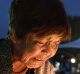 A woman lights a candle as she prays for the atomic bomb victims in front of the cenotaph at the Hiroshima Peace ...