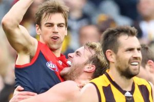 Hawks skipper Luke Hodge looks dejected as Demons Dom Tyson and Jack Watts celebrate the round 20 win. 