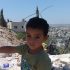 Young boy stands in the ruins of his home of 4 years