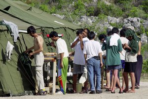 In this Sept. 21, 2001, file photo, Men shave, brush their teeth and prepare for the day at a refugee camp on the Island of Nauru. Human rights groups accused Australia on Wednesday, Aug. 3, 2016, of deliberately ignoring the abuse of asylum seekers being held at the remote Pacific island detention camp.