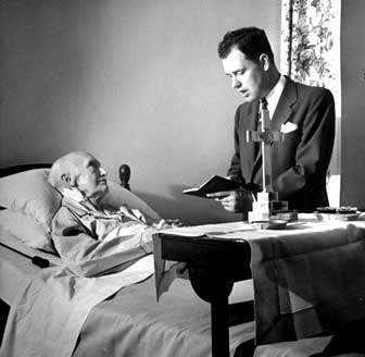 A hospital chaplain delivering as dose of mumbo-jumbo to an ailing patient