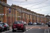 An automobile passes a row of brick terraced houses in Dublin, Ireland.