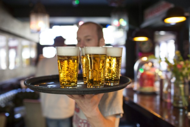 A barman carries a tray of draught Grolsch beer glasses, produced by SABMiller Plc, in a bar in Utrecht, Netherlands.