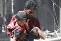 A Syrian man helps a wounded boy in Aleppo, Syria.