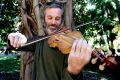 Can you play some Bach? Mikey Floyd demonstrates his exquisite violin made from the garden's 'waste' timber.