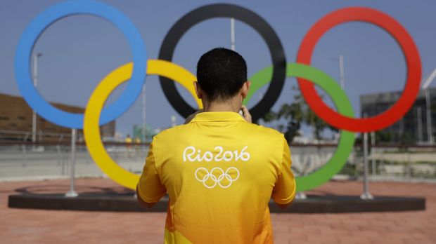 A volunteer photographs a set of Olympic Rings