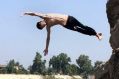 Iraqis jump off the ruins of an old building into the Tigris River to beat the heat in Baghdad this month. The ...