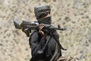 In this Friday, May 27, 2016 photo, a member of a breakaway faction of the Taliban fighters guards a gathering in Shindand district of Herat province, Afghanistan.