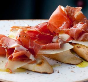 Baguette slices rubbed with tomato and olive oil, topped with manchego and jamon from Chato Tapas.