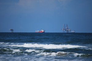 Oil rigs and tanker off the coast of the municipality. The municipality has 57,755 hectares of land with 17% used for agriculture, 16% for livestock, 12% forest and 55% is residential/urban, wetlands or bodies of water.