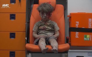 In this frame grab taken from video provided by the Syrian anti-government activist group Aleppo Media Center (AMC), a child sits in an ambulance after being pulled out or a building hit by an airstirke, in Aleppo, Syria, Wednesday, Aug. 17, 2016.