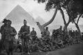 Far from home: Australian infantry resting beside the tramline near Mena, with the Giza pyramids behind them.