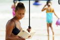 Kirsty Hatcher 18, makes good use of her umbrella on the beach in Bournemouth, England, Tuesday July 15, 2003 as ...