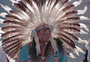 The headdress of Comanche medicine man George Woogee Watchetaker billows in the wind as he looks on during ceremonies honoring native American Codetalkers at the capitol in Oklahoma City, Okla., on Nov. 4, 1989.