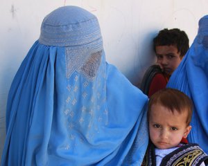 File - An Afghan mother, veiled by a burqa, holds her son on her lap as they wait to be seen at the Obdara clinic, where medical personnel from the provincial reconstruction team in Afghanistan’s Panjshir province assisted a local midwife and nurse, Oct. 16, 2008.