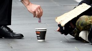 Prime Minister Malcolm Turnbull gives a homeless man five dollars.