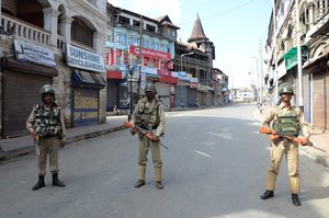 Indian paramilitary troopers stand guard during a curfew in Srinagar on August 17, 2016. Suspected militants killed two soldiers and one police officer in an ambush on a convoy overnight in Indian-administrated Kashmir, an official in the troubled region said. An unknown number of gunmen opened fire on the two army trucks and a police car travelling through Baramulla district, 60 kilometres (37 miles) west of the region's main city of Srinagar.Kashmir has been under curfew since protests erupted over the death last month of a popular young rebel leader, Burhan Wani, in a gunfight with security forces.