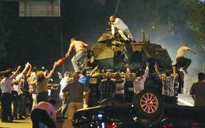 In this file photo dated early morning Saturday, July 16, 2016, a tank moves into position as Turkish people clamber onto it, attempting to stop the military coup, in Ankara, Turkey.  Turkish President Recep Erdogan has called on the United States not to delay the extradition of Muslim cleric Fethullah Gulen, whom Turkey accuses of orchestrating last month's coup attempt.