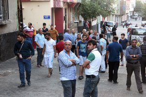 People gather to view damage just hours after Saturday's bomb attack in Gaziantep, southeastern Turkey, early Sunday, Aug. 21, 2016, targeting an outdoor wedding party in southeastern Turkey killed dozens of people and wounded dozens