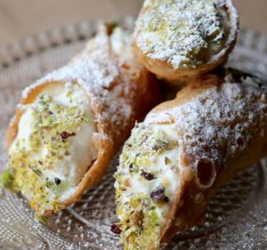 Cannoli stuffed with ricotta and dipped in pistachio is a Sicilian dessert staple.