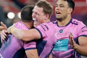 Cameron Smith of the Storm is swamped after nailing a golden point field goal against the Rabbitohs in Round 22.