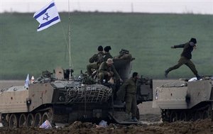 Israeli soldiers prepare their armored vehicles outside the Gaza Strip, southern Israel, Monday, Jan. 5, 2009. Israel seized control of high-rise buildings and attacked houses, mosques and smuggling tunnels as it pressed forward with its offensive against the Gaza Strip's Hamas rulers on Monday, even as a stream of European leaders headed for the region to press for a truce.