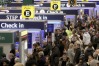 Passengers queue to check-in at Heathrow Airport in London.
