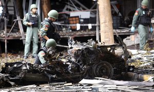 Thai bomb squad officers examine the wreckage of a car after an explosion outside a hotel in Pattani province, southern Thailand,  Wednesday, Aug. 24, 2016.