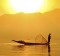 A fisherman plys his trade on Inle Lake at sunset.