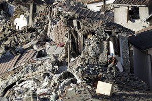 Rescuers make their way through destroyed houses following an earthquake in Pescara Del Tronto, central Italy, Thursday, Aug. 25, 2016.