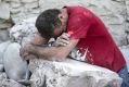 A man leans on rubble following the earthquake in Amatrice.