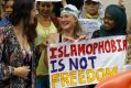 Activists protest outside the French embassy during, the "wear what you want beach party" in London.